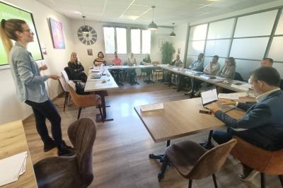 Miniature Location salle La Garde (Var) - City Var #18 Salle de réunion lumineuse avec plusieurs tables, chaises variées, plantes vertes et un écran mural.