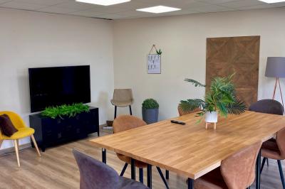 Miniature Location salle La Garde (Var) - City Var #13 Salle de réunion lumineuse avec plusieurs tables, chaises variées, plantes vertes et un écran mural.