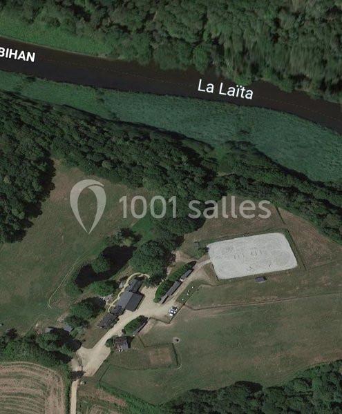 Vue aérienne d'un paysage rural avec des bâtiments, un champ, une rivière nommée ’La Laïta’ et une zone claire aménagée.