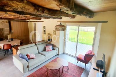 Illustration d'un logo avec des branches de feuillage pastel entourant le texte ’Le Domaine des Cavaliers’.