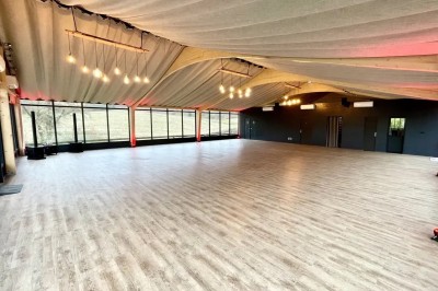 Illustration d'un logo avec des branches de feuillage pastel entourant le texte ’Le Domaine des Cavaliers’.