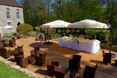 Un couple en tenue de mariage se tient sur un balcon en pierre devant une fenêtre illuminée.
