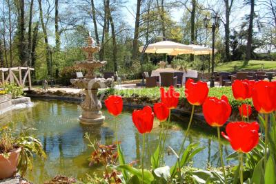 Un couple en tenue de mariage se tient sur un balcon en pierre devant une fenêtre illuminée.