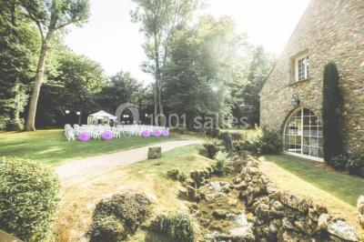 Un couple en tenue de mariage se tient sur un balcon en pierre devant une fenêtre illuminée.