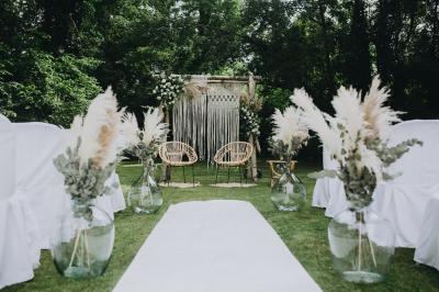 Un couple en tenue de mariage se tient sur un balcon en pierre devant une fenêtre illuminée.