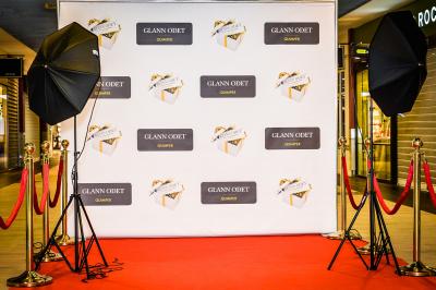Sapin de Noël décoré de boules dorées et entouré de sacs cadeaux dans un magasin.