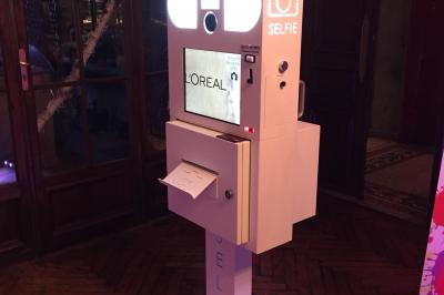 Sapin de Noël décoré de boules dorées et entouré de sacs cadeaux dans un magasin.