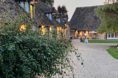 Platines vinyles et disques exposés sur une table en extérieur, avec un jardin verdoyant et un pigeonnier à colombages en…