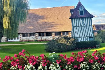 Platines vinyles et disques exposés sur une table en extérieur, avec un jardin verdoyant et un pigeonnier à colombages en…