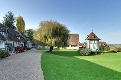 Platines vinyles et disques exposés sur une table en extérieur, avec un jardin verdoyant et un pigeonnier à colombages en…