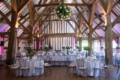 Platines vinyles et disques exposés sur une table en extérieur, avec un jardin verdoyant et un pigeonnier à colombages en…