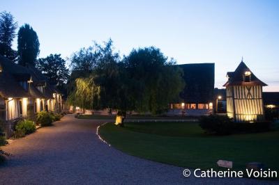 Platines vinyles et disques exposés sur une table en extérieur, avec un jardin verdoyant et un pigeonnier à colombages en…