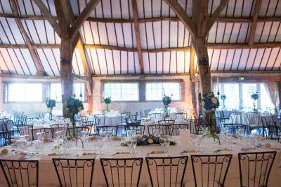 Platines vinyles et disques exposés sur une table en extérieur, avec un jardin verdoyant et un pigeonnier à colombages en…