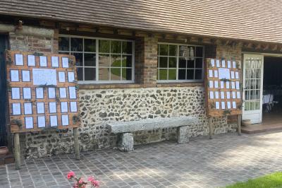 Platines vinyles et disques exposés sur une table en extérieur, avec un jardin verdoyant et un pigeonnier à colombages en…