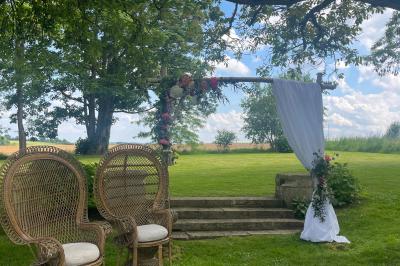 Platines vinyles et disques exposés sur une table en extérieur, avec un jardin verdoyant et un pigeonnier à colombages en…