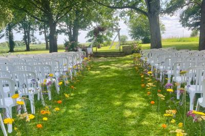 Platines vinyles et disques exposés sur une table en extérieur, avec un jardin verdoyant et un pigeonnier à colombages en…