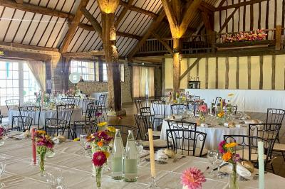 Platines vinyles et disques exposés sur une table en extérieur, avec un jardin verdoyant et un pigeonnier à colombages en…