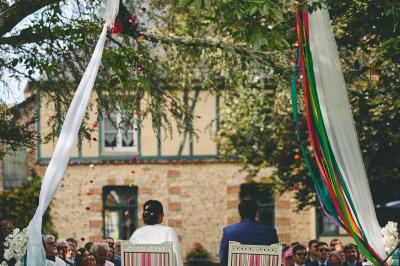 Platines vinyles et disques exposés sur une table en extérieur, avec un jardin verdoyant et un pigeonnier à colombages en…
