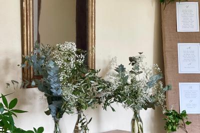 Platines vinyles et disques exposés sur une table en extérieur, avec un jardin verdoyant et un pigeonnier à colombages en…