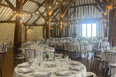 Platines vinyles et disques exposés sur une table en extérieur, avec un jardin verdoyant et un pigeonnier à colombages en…