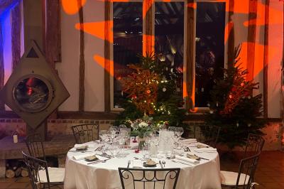 Platines vinyles et disques exposés sur une table en extérieur, avec un jardin verdoyant et un pigeonnier à colombages en…