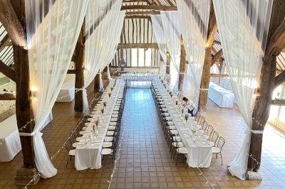 Platines vinyles et disques exposés sur une table en extérieur, avec un jardin verdoyant et un pigeonnier à colombages en…