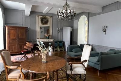 Platines vinyles et disques exposés sur une table en extérieur, avec un jardin verdoyant et un pigeonnier à colombages en…