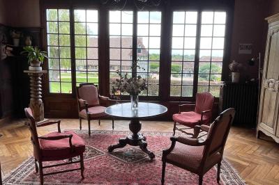 Platines vinyles et disques exposés sur une table en extérieur, avec un jardin verdoyant et un pigeonnier à colombages en…