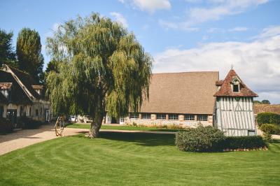 Platines vinyles et disques exposés sur une table en extérieur, avec un jardin verdoyant et un pigeonnier à colombages en…