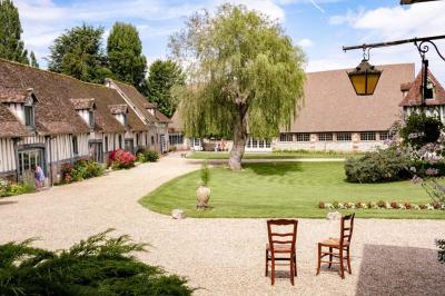 Platines vinyles et disques exposés sur une table en extérieur, avec un jardin verdoyant et un pigeonnier à colombages en…