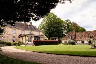 Platines vinyles et disques exposés sur une table en extérieur, avec un jardin verdoyant et un pigeonnier à colombages en…
