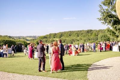 Platines vinyles et disques exposés sur une table en extérieur, avec un jardin verdoyant et un pigeonnier à colombages en…
