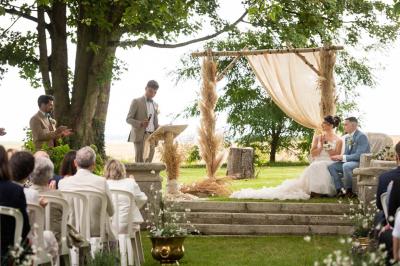 Platines vinyles et disques exposés sur une table en extérieur, avec un jardin verdoyant et un pigeonnier à colombages en…