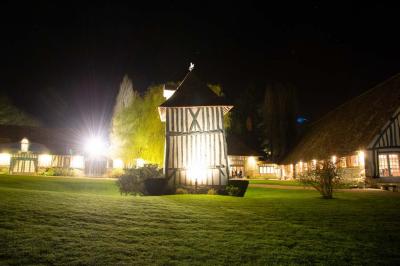 Platines vinyles et disques exposés sur une table en extérieur, avec un jardin verdoyant et un pigeonnier à colombages en…