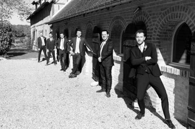 Platines vinyles et disques exposés sur une table en extérieur, avec un jardin verdoyant et un pigeonnier à colombages en…