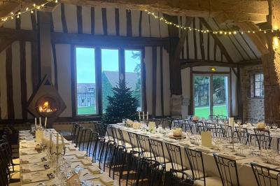 Platines vinyles et disques exposés sur une table en extérieur, avec un jardin verdoyant et un pigeonnier à colombages en…