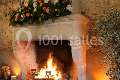 Miniature Location salle Corny (Eure) - Le Manoir de Corny #3 Brasero allumé dans une cour gravillonnée devant un bâtiment éclairé avec des murs en bois et des portes vitrées.