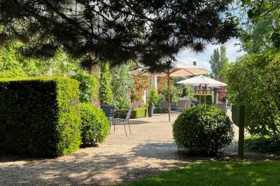 Miniature Location salle Corny (Eure) - Le Manoir de Corny #9 Brasero allumé dans une cour gravillonnée devant un bâtiment éclairé avec des murs en bois et des portes vitrées.