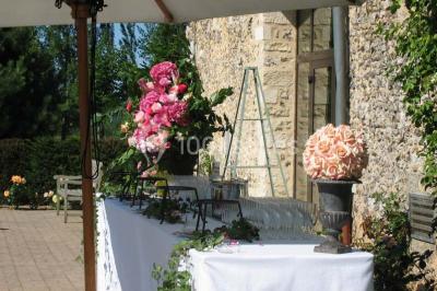 Miniature Location salle Corny (Eure) - Le Manoir de Corny #7 Brasero allumé dans une cour gravillonnée devant un bâtiment éclairé avec des murs en bois et des portes vitrées.