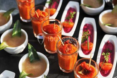 Miniature Location salle Corny (Eure) - Le Manoir de Corny #10 Brasero allumé dans une cour gravillonnée devant un bâtiment éclairé avec des murs en bois et des portes vitrées.