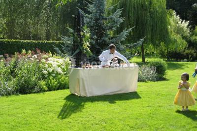 Miniature Location salle Corny (Eure) - Le Manoir de Corny #8 Brasero allumé dans une cour gravillonnée devant un bâtiment éclairé avec des murs en bois et des portes vitrées.