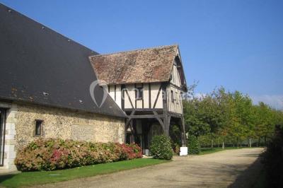 Miniature Location salle Corny (Eure) - Le Manoir de Corny #18 Brasero allumé dans une cour gravillonnée devant un bâtiment éclairé avec des murs en bois et des portes vitrées.