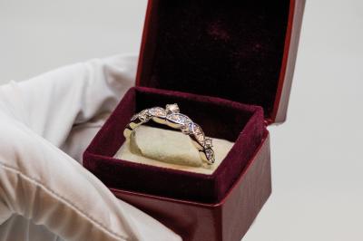 Anneaux en métal de différentes formes, textures et couleurs suspendus en arc sur fond blanc.