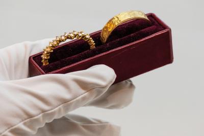 Anneaux en métal de différentes formes, textures et couleurs suspendus en arc sur fond blanc.