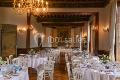 Bâtiment ancien avec façade décrépite, entouré d'une cour herbeuse et d'arbres dénudés en arrière-plan.