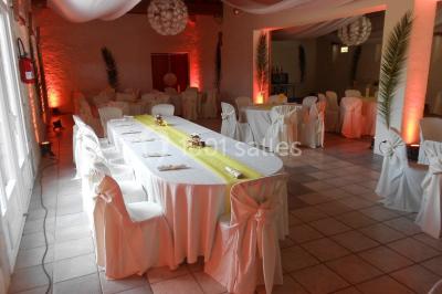 Cuisine professionnelle avec plans de travail en inox, hotte d'extraction, évier et carrelage mural blanc.