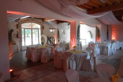 Cuisine professionnelle avec plans de travail en inox, hotte d'extraction, évier et carrelage mural blanc.