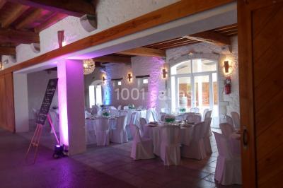 Cuisine professionnelle avec plans de travail en inox, hotte d'extraction, évier et carrelage mural blanc.