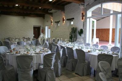 Cuisine professionnelle avec plans de travail en inox, hotte d'extraction, évier et carrelage mural blanc.