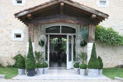 Cuisine professionnelle avec plans de travail en inox, hotte d'extraction, évier et carrelage mural blanc.